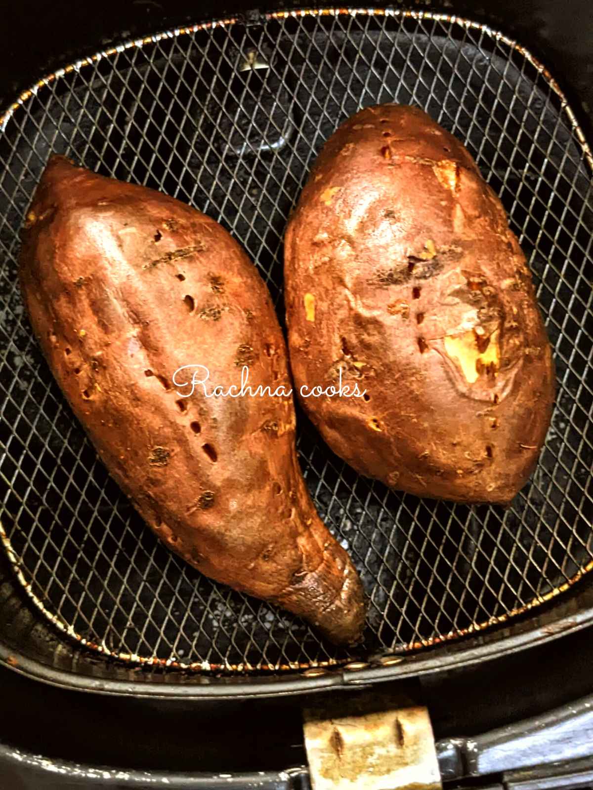 2 sweet potatoes after air frying in air fryer basket 