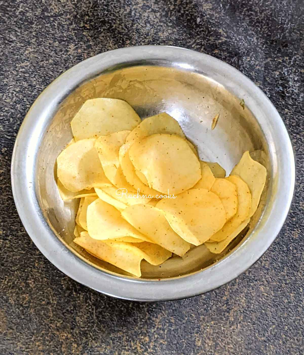 Potato slices tossed with oil and seasonings.
