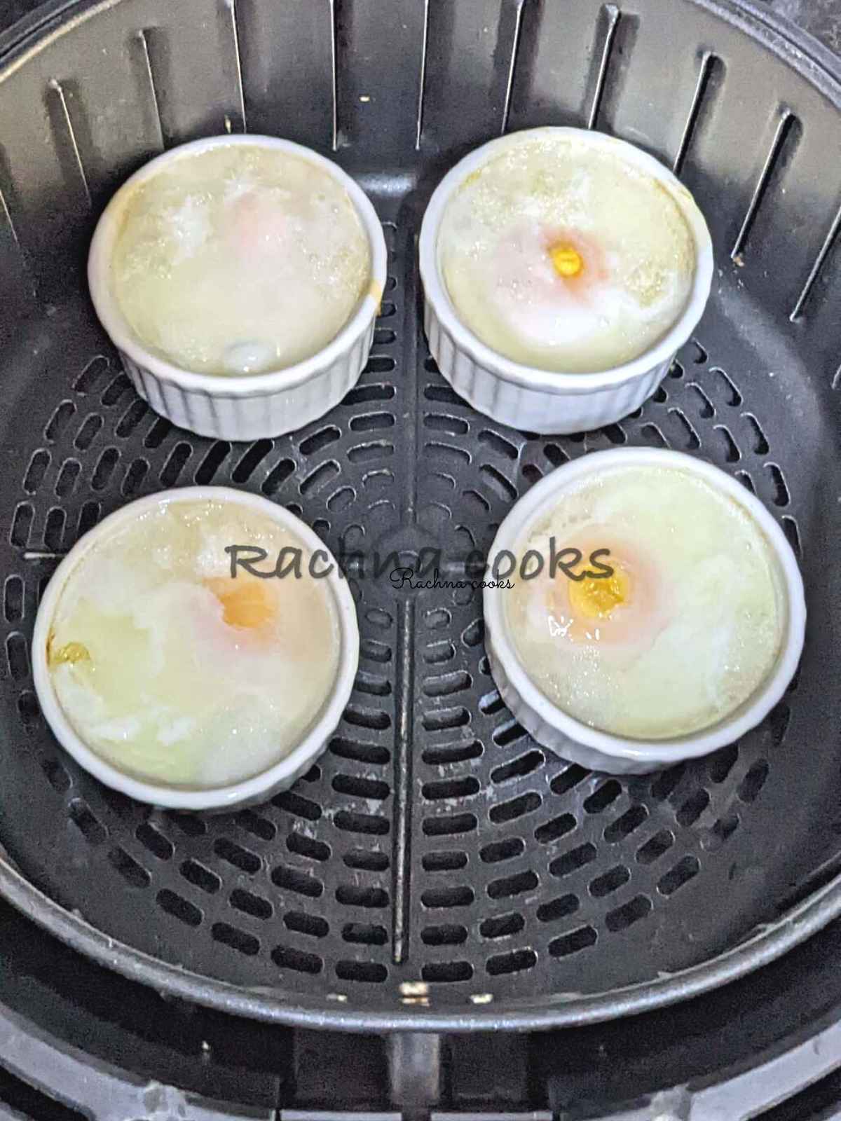 Perfectly poached 4 eggs in ramekins placed in air fryer basket.