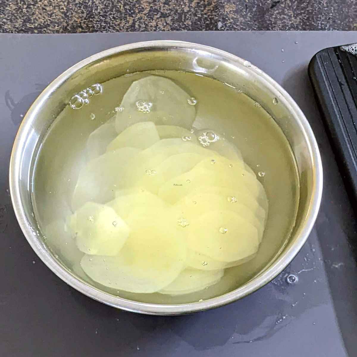 Thin potato slices soaked in cold water