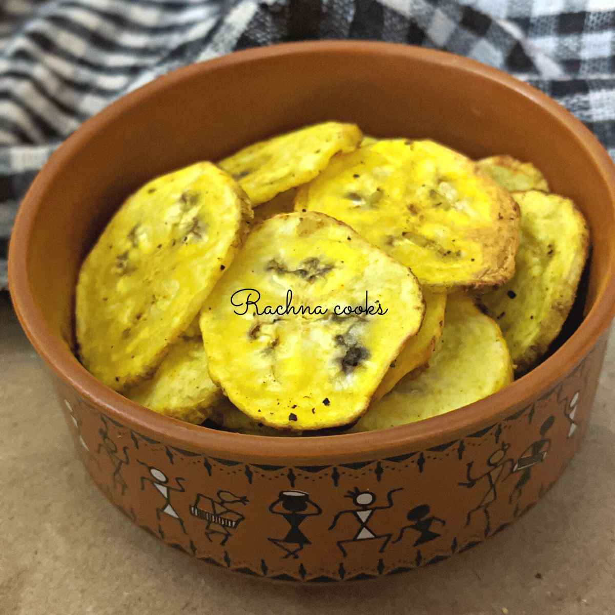 Golden plantain chips after air frying in a brown bowl.