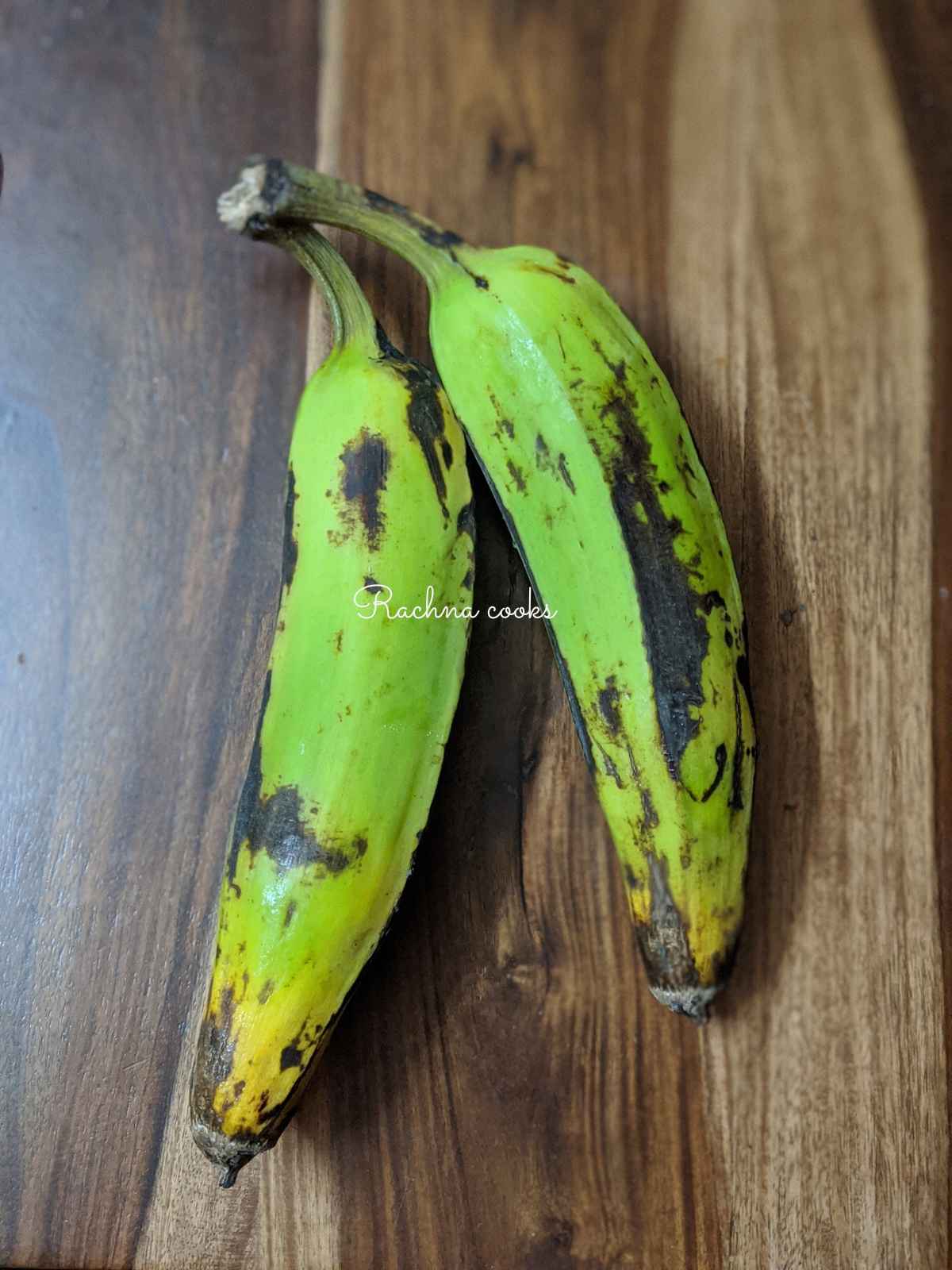 2 plantains placed on a brown surface