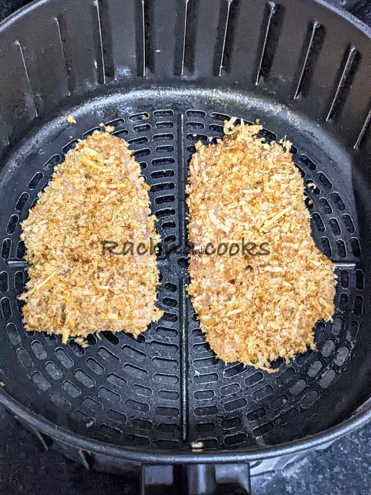 2 breaded chicken fillets in an air fryer basket