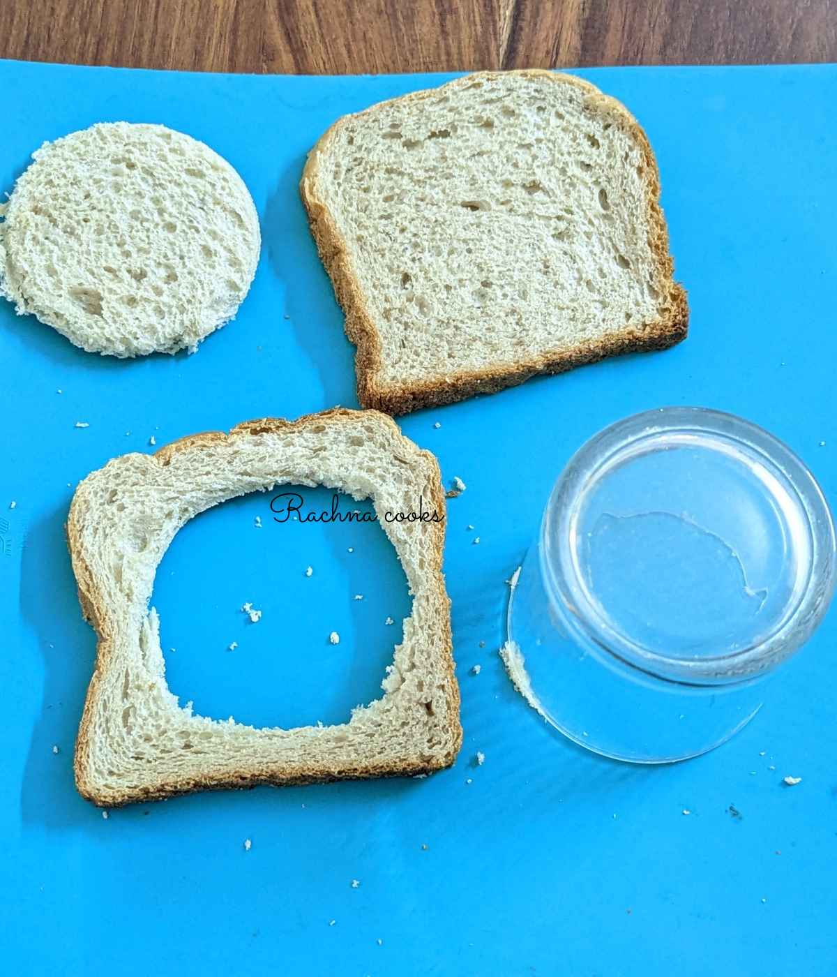 A bread slice with a hole cut out using a glass along with another whole bread.