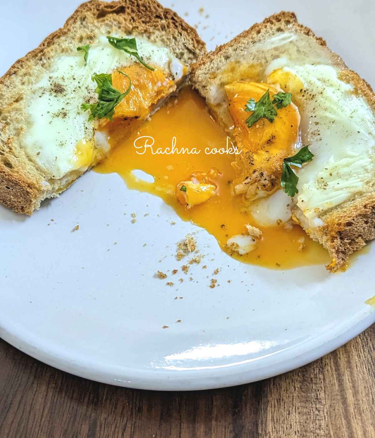One egg toast cut into half with yolk spilling out.
