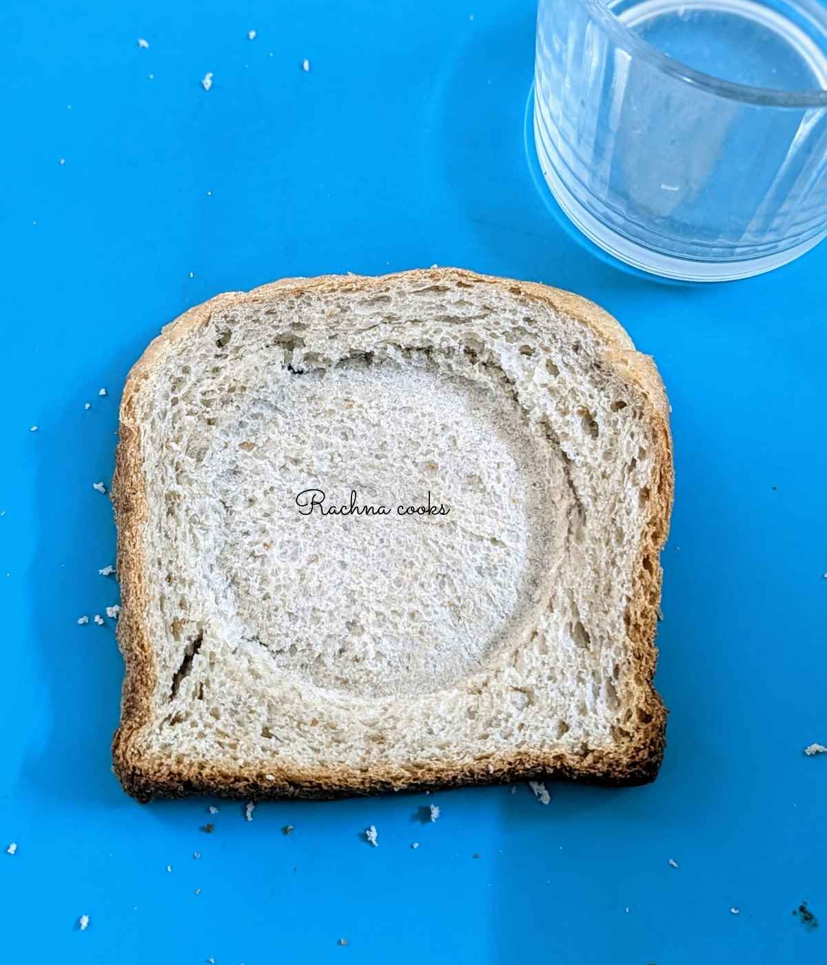 One slice of bread pressed down with glass in the centre to form a cavity.