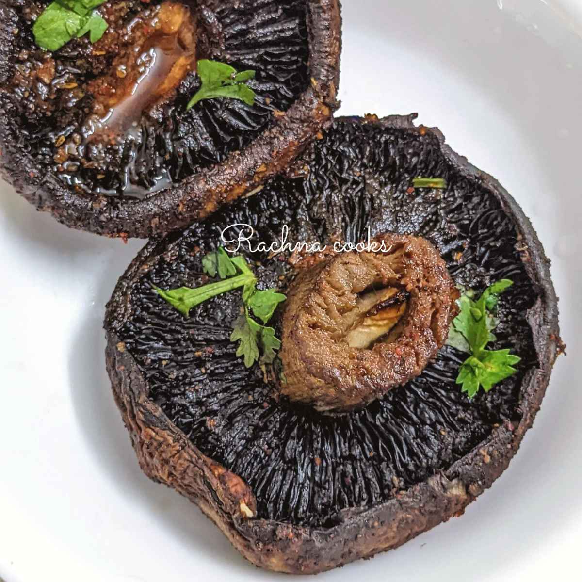 2 delicious air fried portobello mushrooms stalk side up on a glass plate garnished with cilantro