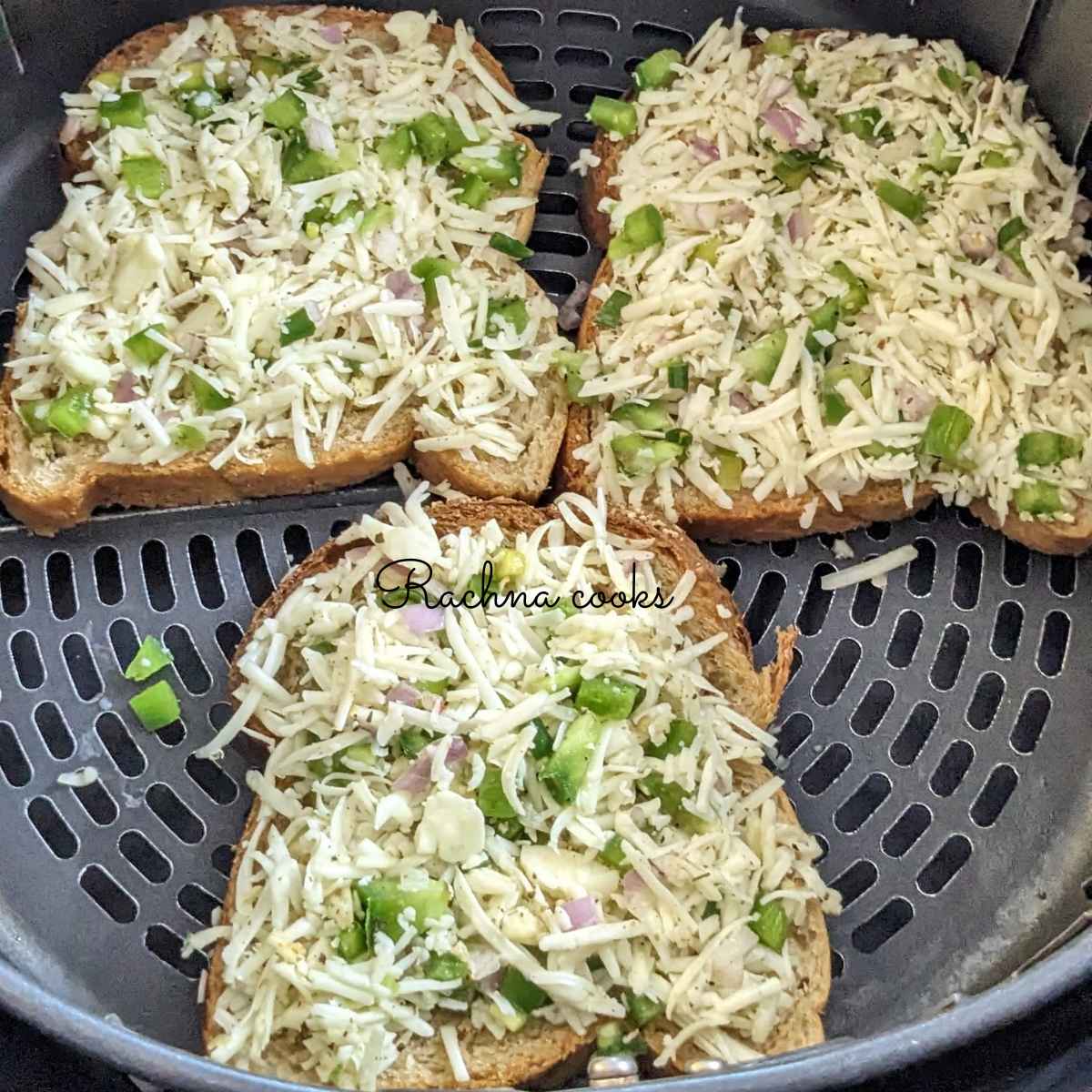 3 slices chilli cheese toast in air fryer basket ready for air frying.