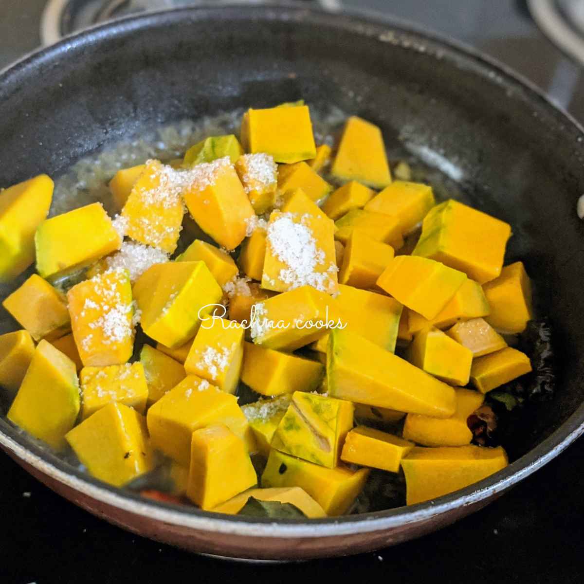 Cubed pumpkin pieces with salt in a wok