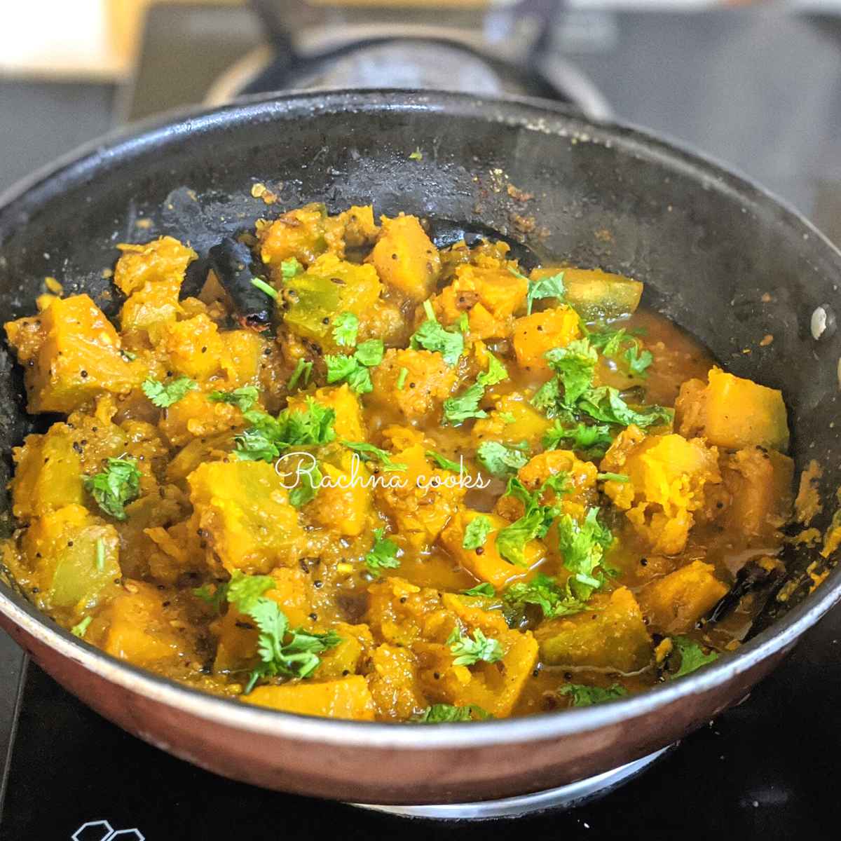 Pumpkin curry garnished with cilantro leaves in a wok