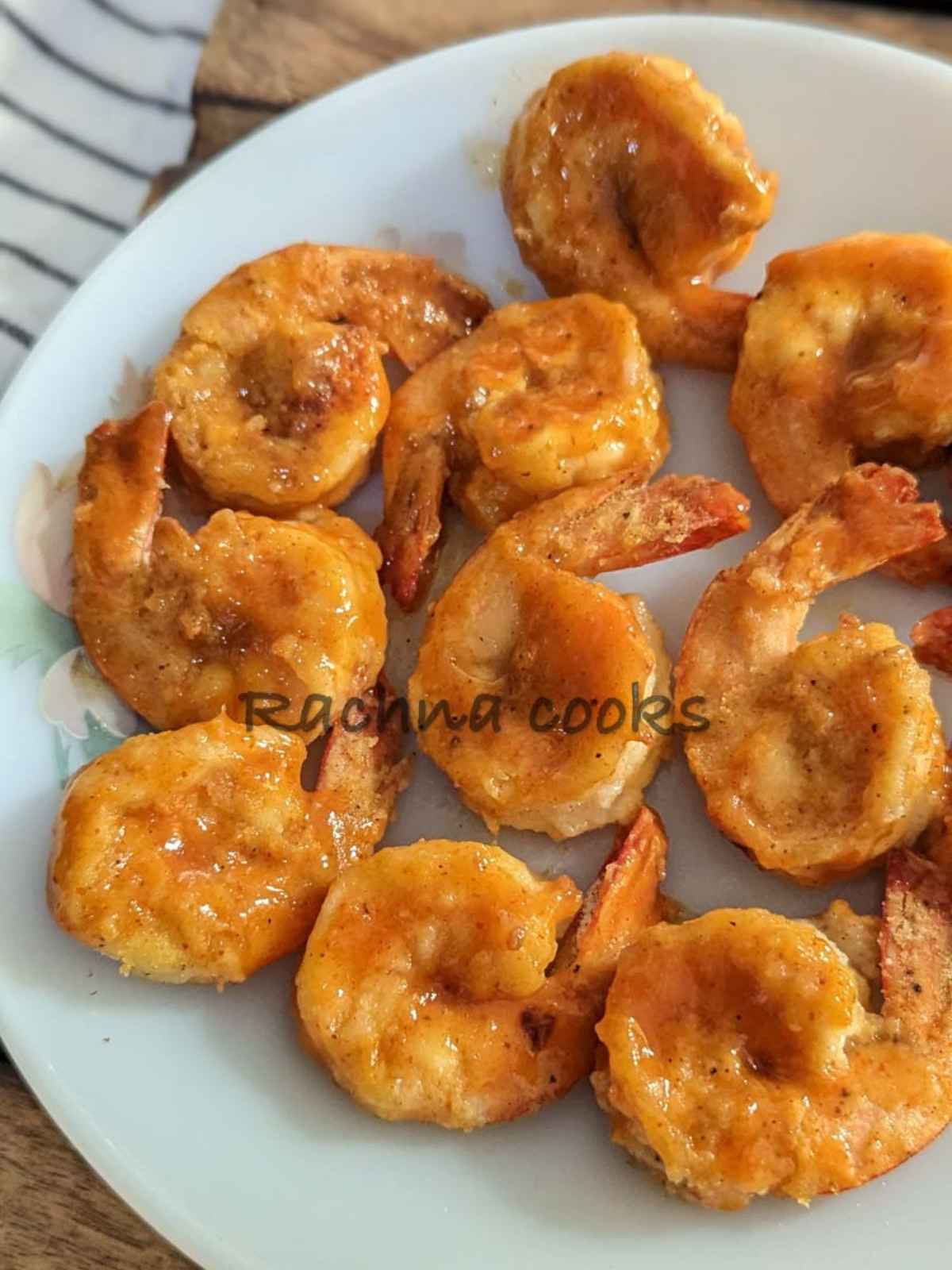 A close up of air fried Buffalo shrimp served on a white plate.