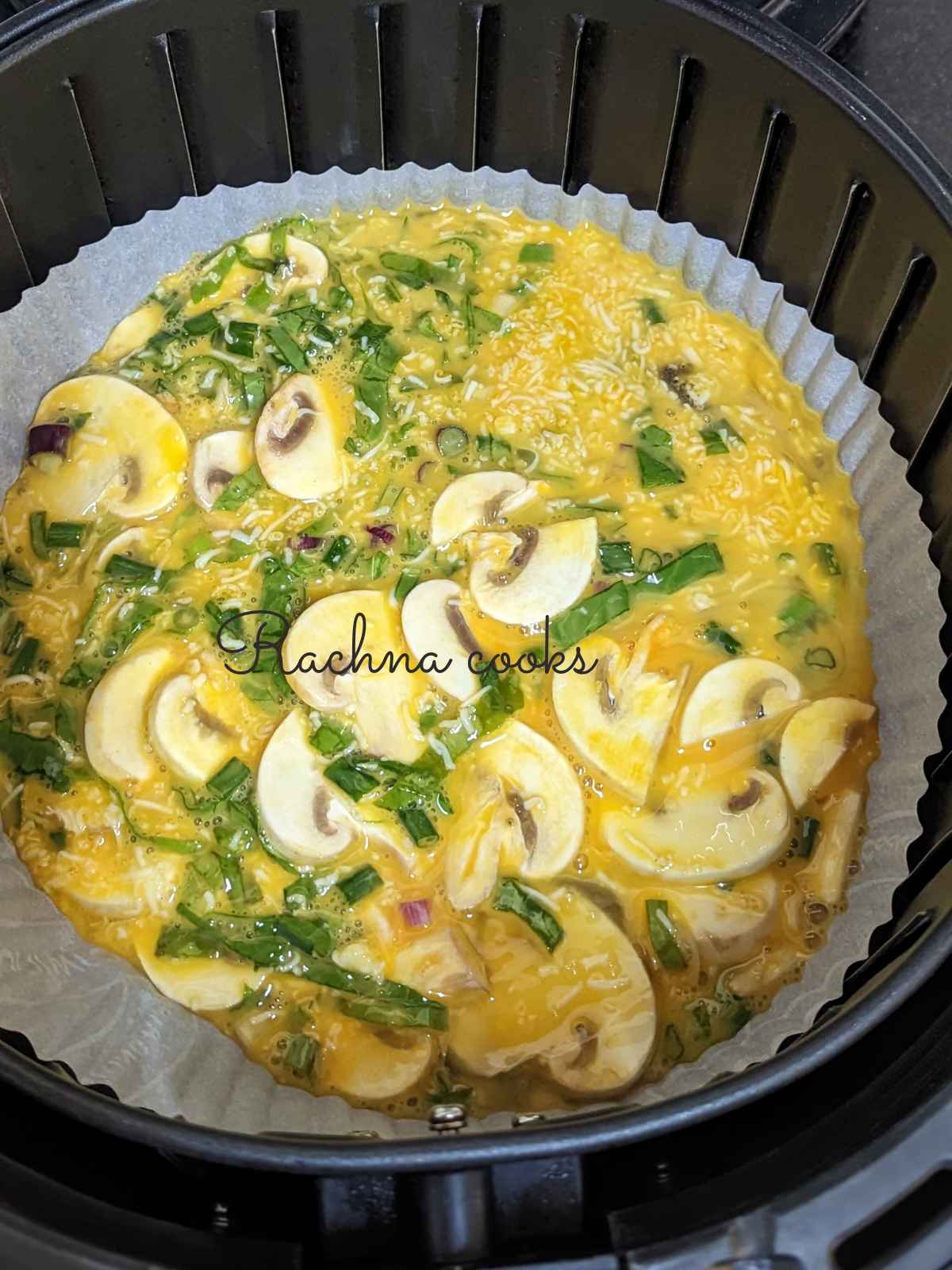 Frittata mix poured into a parchment paper bowl placed in air fryer basket.