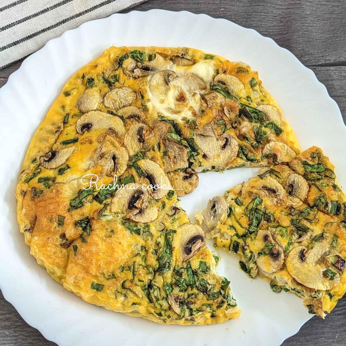 A slice of frittata cut out from the round cooked frittata served on a white plate.
