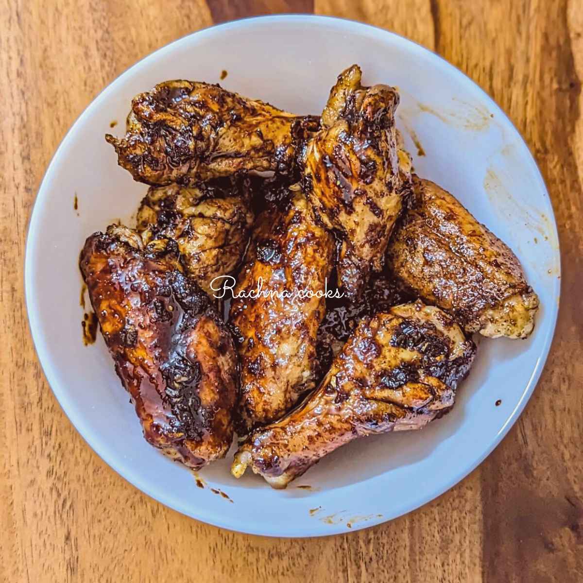 Honey garlic chicken wings after air frying served on a white plate.