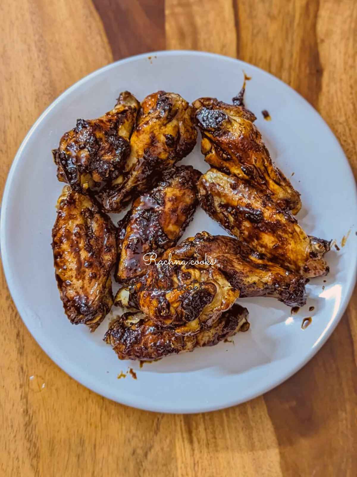 Honey garlic wings served on a white plate.