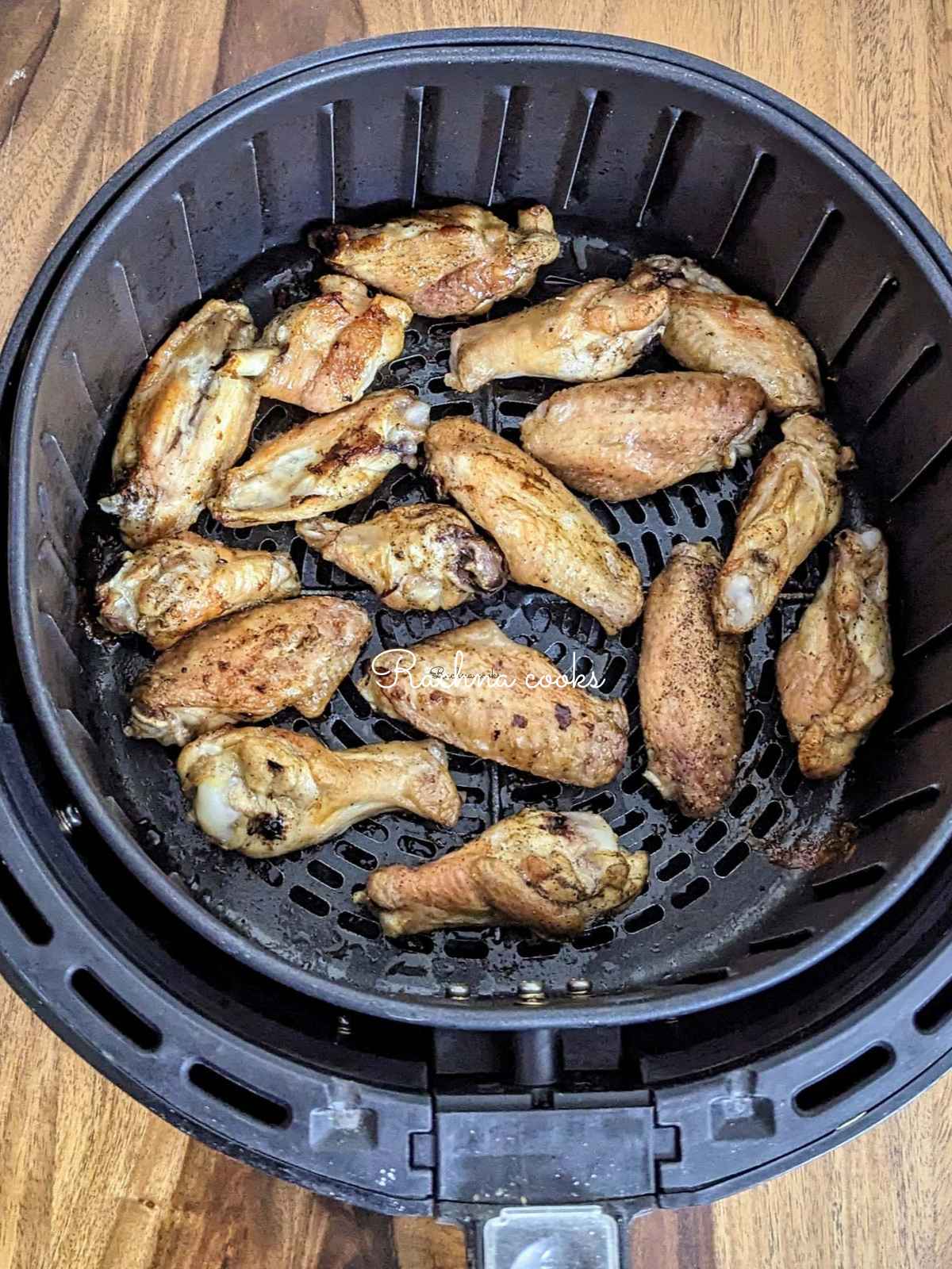 Chicken wings after air frying in air fryer basket.
