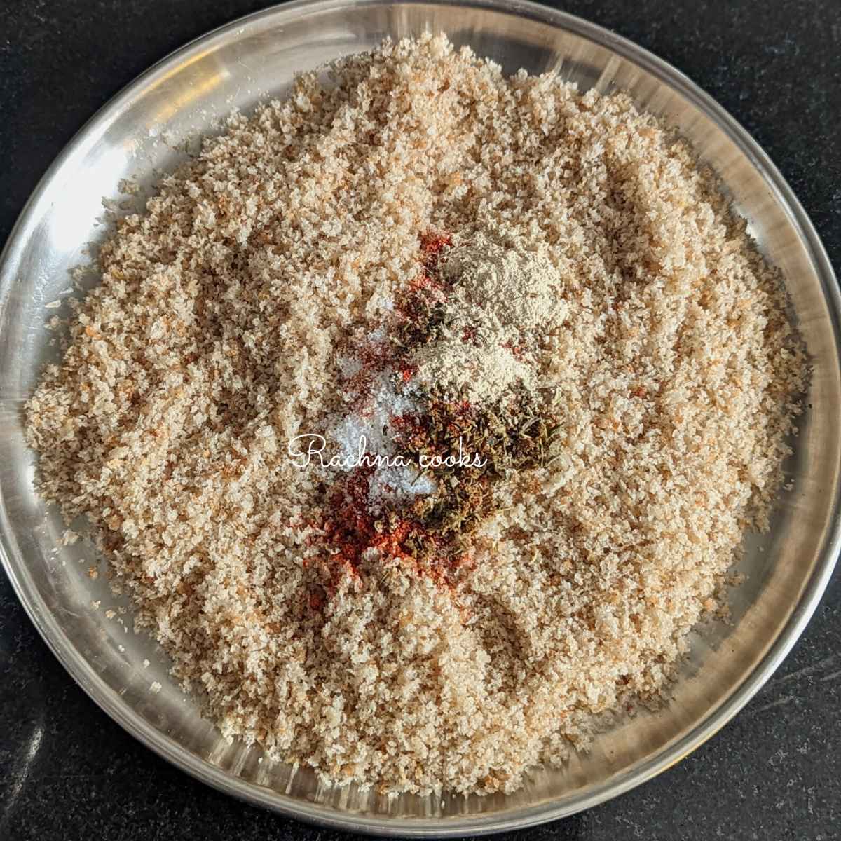 Breadcrumbs in a shallow plate with seasonings and salt