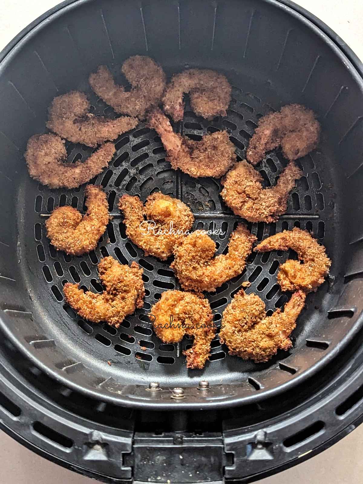 Popcorn shrimp done to perfection in air fryer basket.