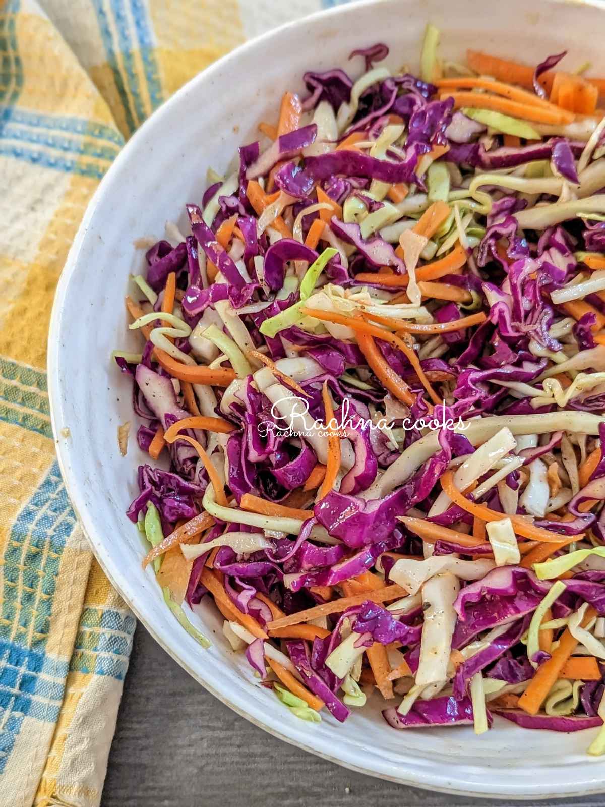 Cabbage and carrot salad served in a large white salad bowl.