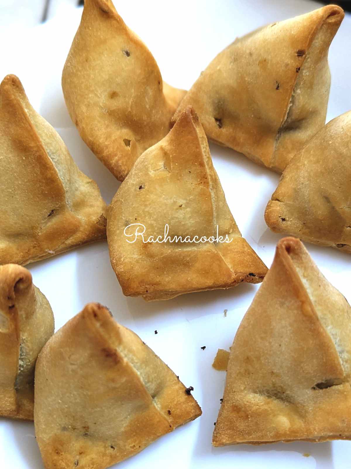 Air fried frozen samosas served on a white plate.