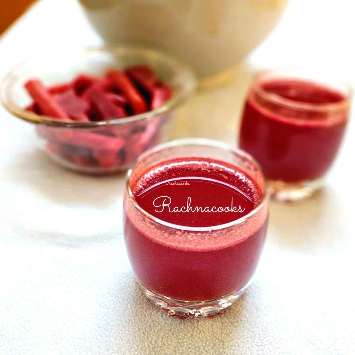 2 glasses of kanji along with pickled beets and carrots in a bowl