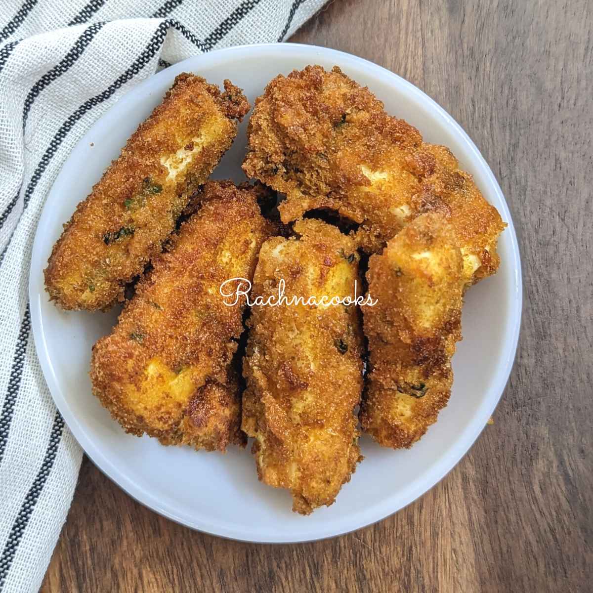 crispy deep fried paneer fingers served in a white bowl.
