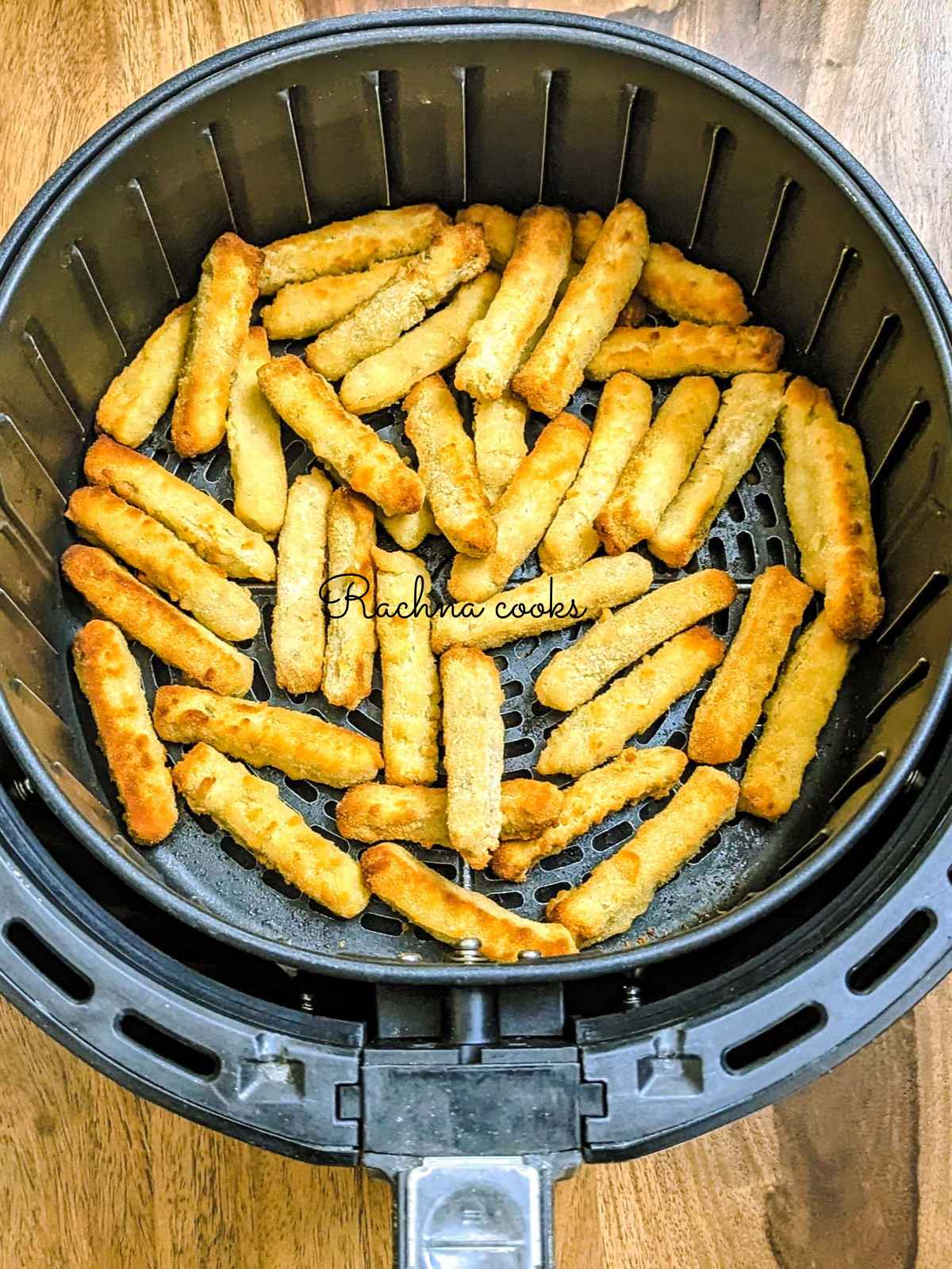 Golden fried chicken fries in air fryer basket after air frying.