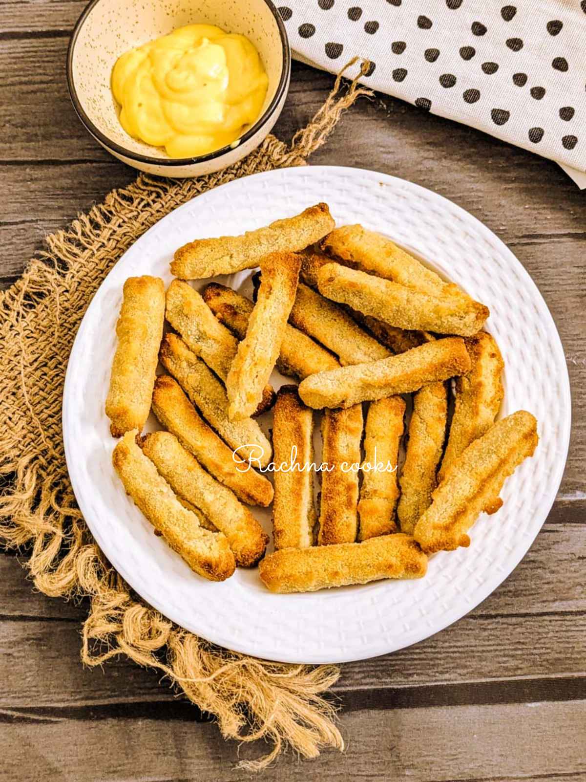 Golden air fried chicken fries in white serving plate with  honey mustard dip served in a bowl.