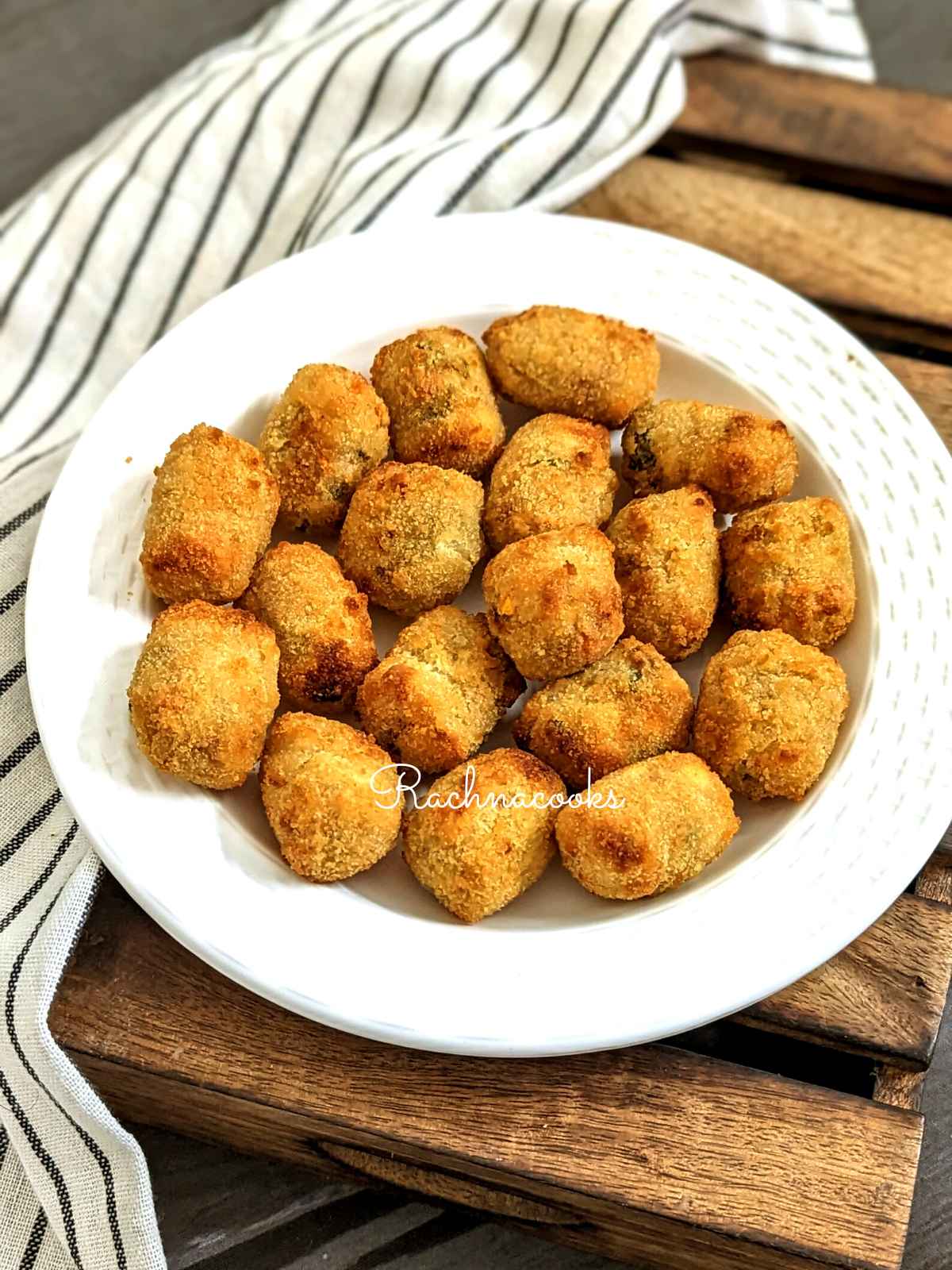 golden brown air fried veggie tots served on a white plate.