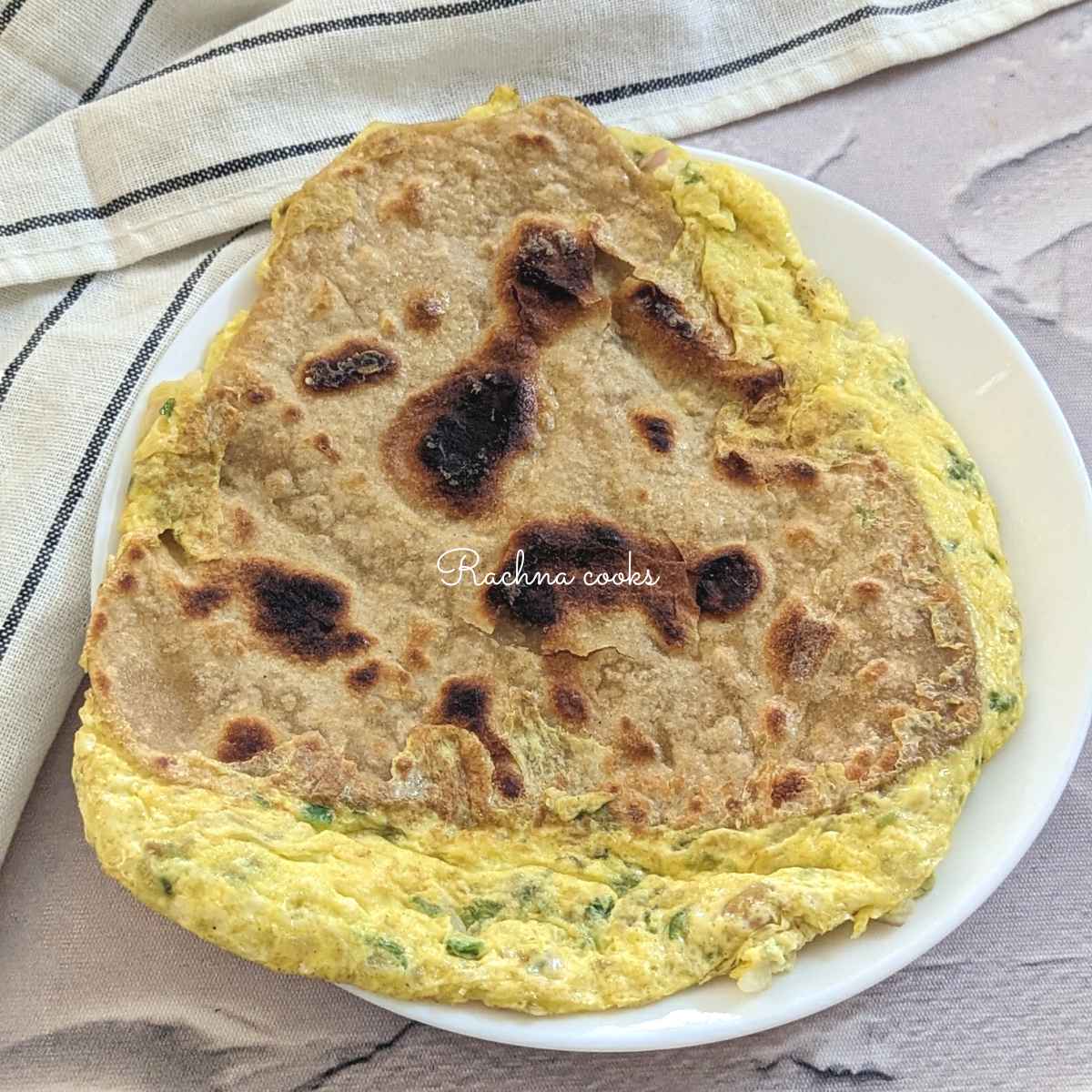 Egg paratha served on a white plate.