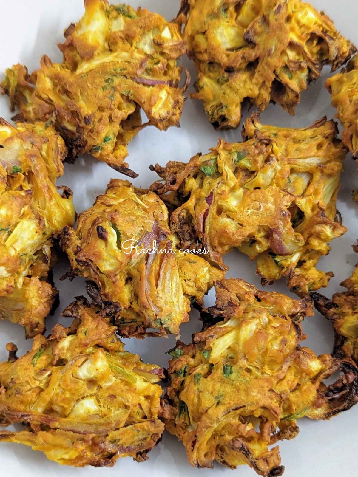 A close up top shot of air fried cabbage pakodas served on a white plate.