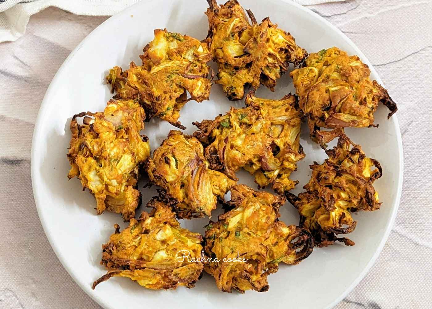 A plate of delicious air fried cabbage pakodas on a white plate.