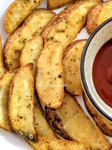 Delicious air fryer golden potato wedges served with ketchup.