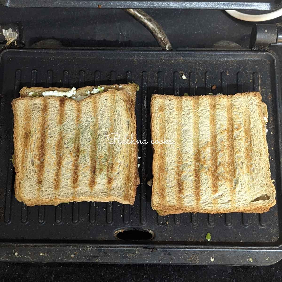 Two Paneer sandwiches in the grill for grilling.