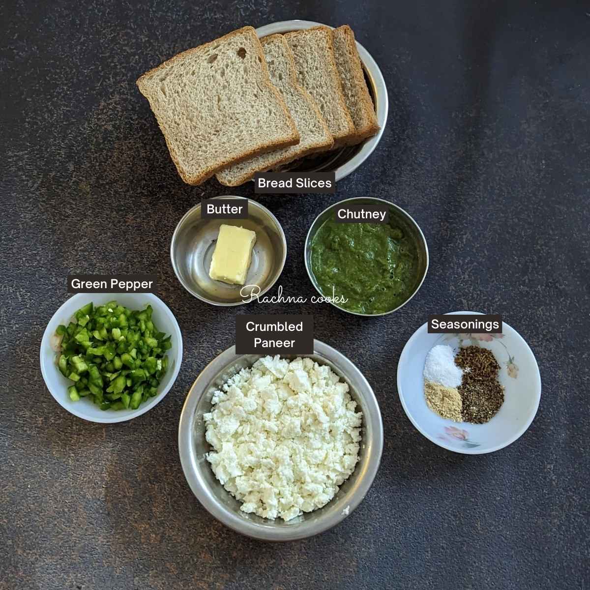 The ingredients for paneer sandwich laid out: Butter, chutney, seasonings, crumbled paneer, green pepper and bread slices.