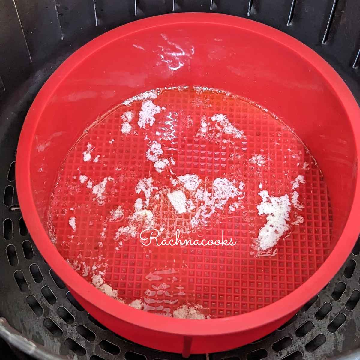 Melted butter in silicone mould in air fryer basket.