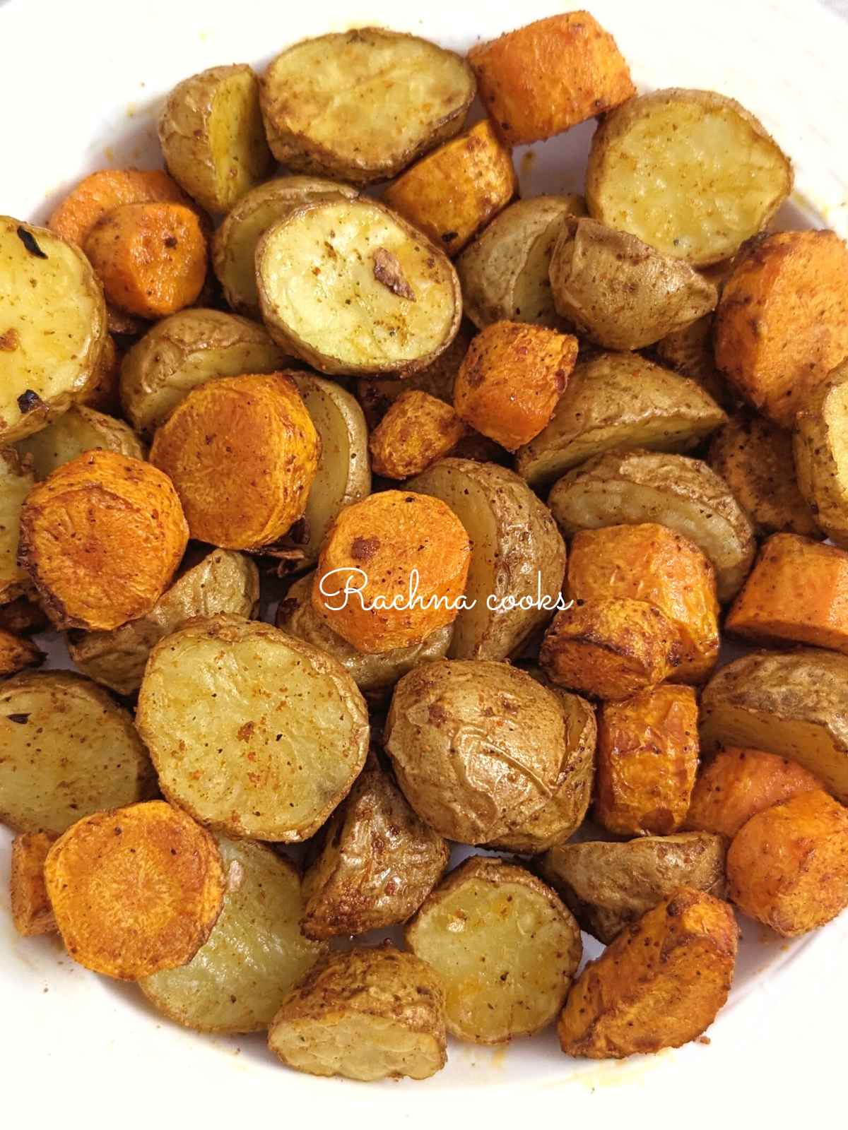 Roasted air fryer carrots and potatoes served on a white plate