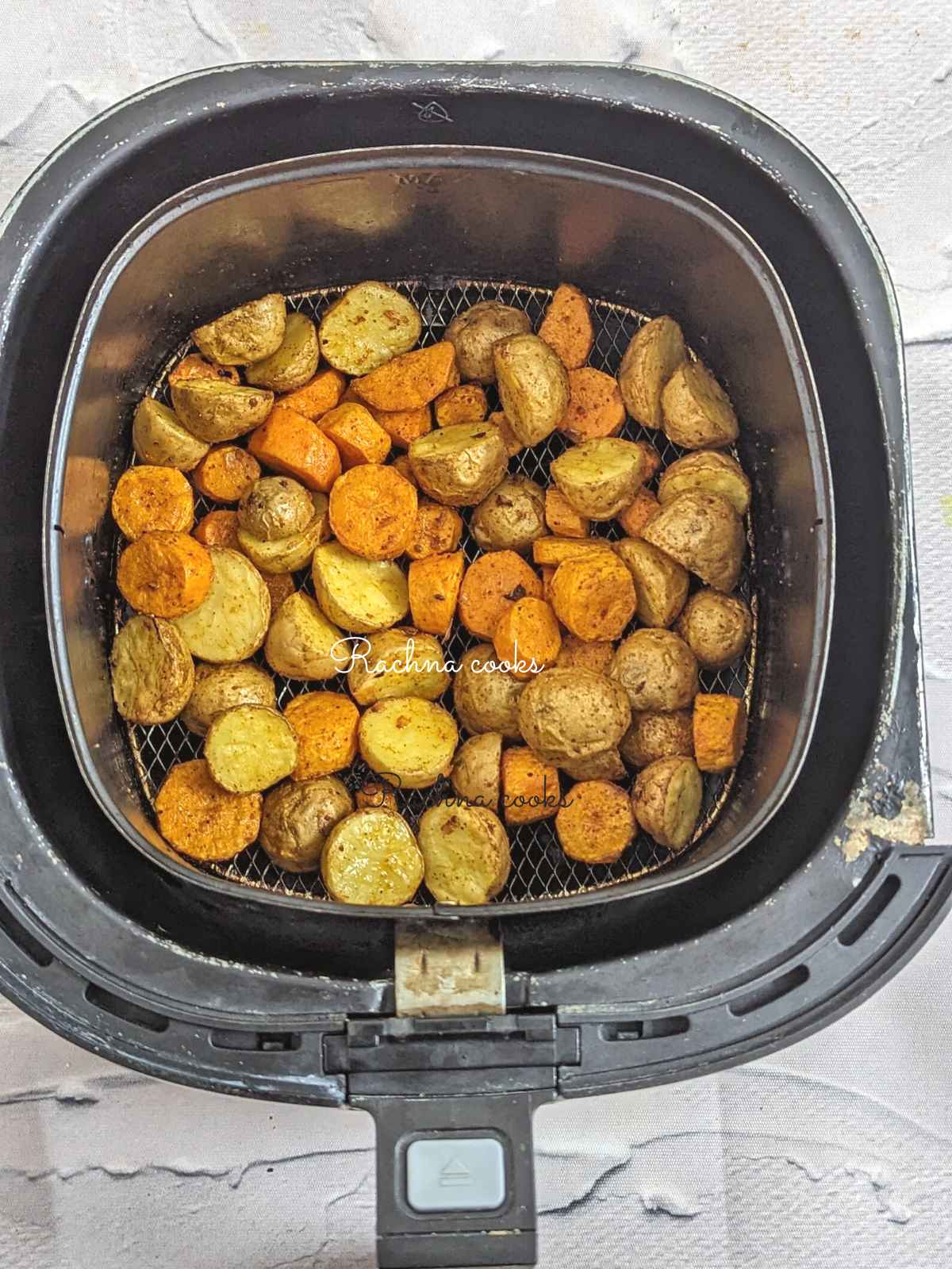 Air fried golden carrots and potatoes after air frying in air fryer basket