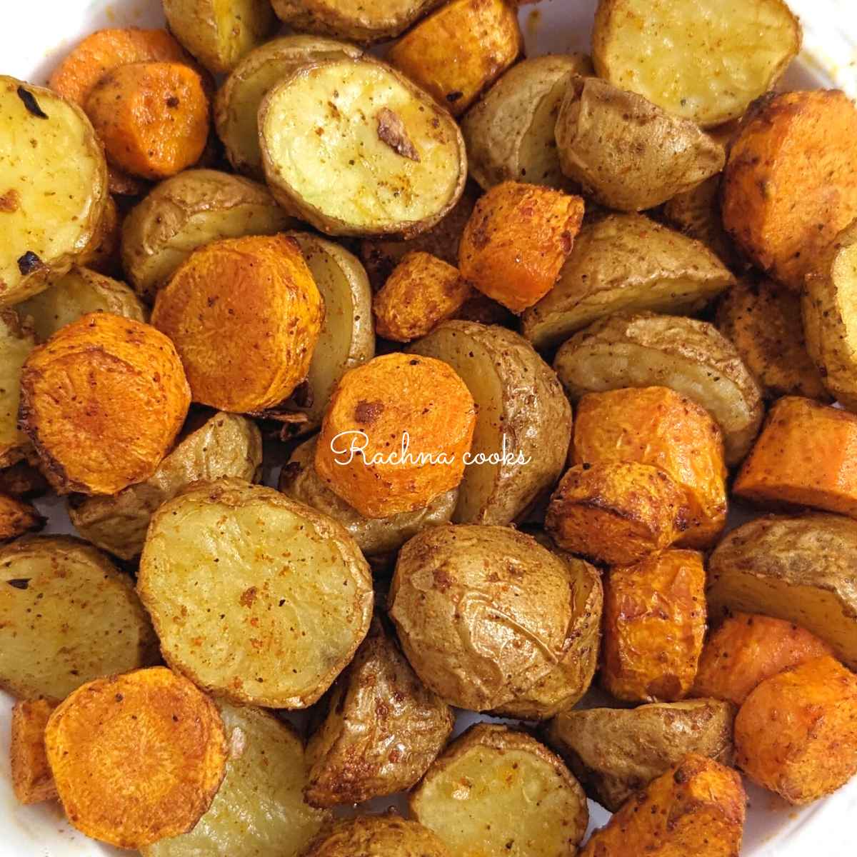 Close up of Roasted air fryer carrots and potatoes served on a white plate