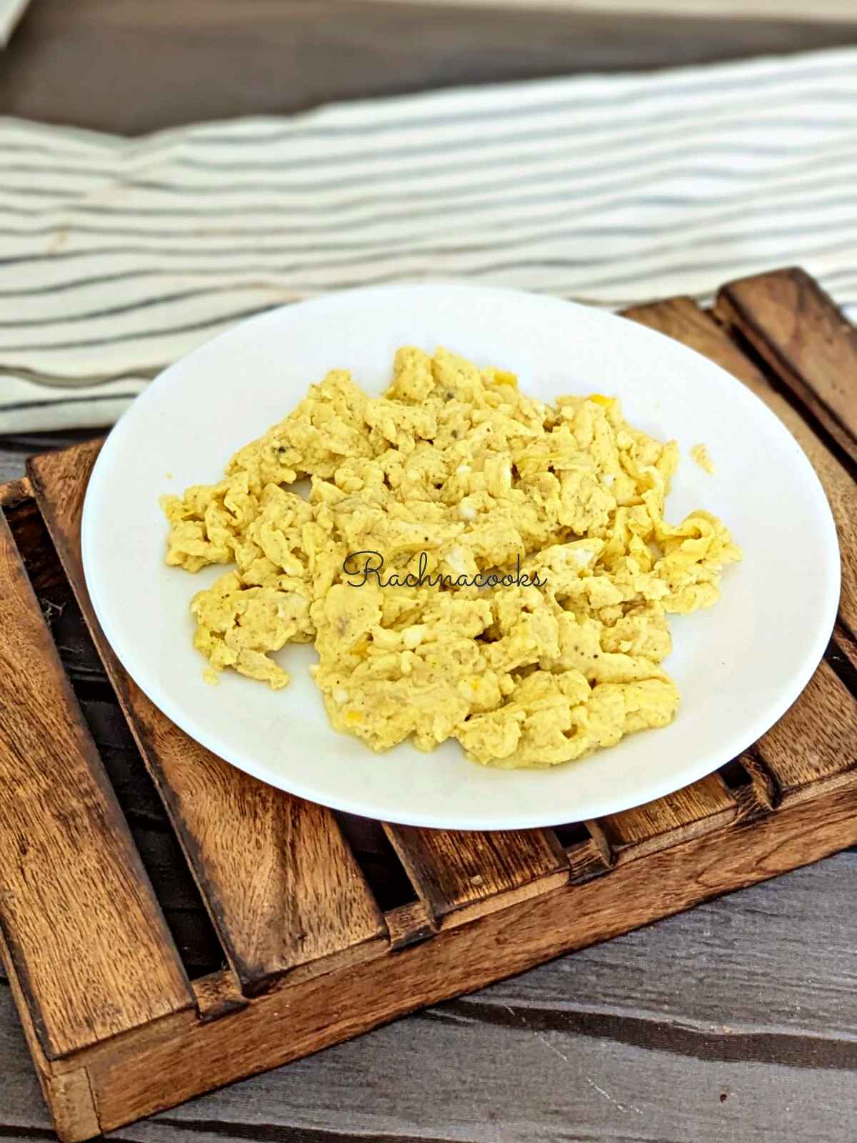 Scrambled eggs served on a white plate.