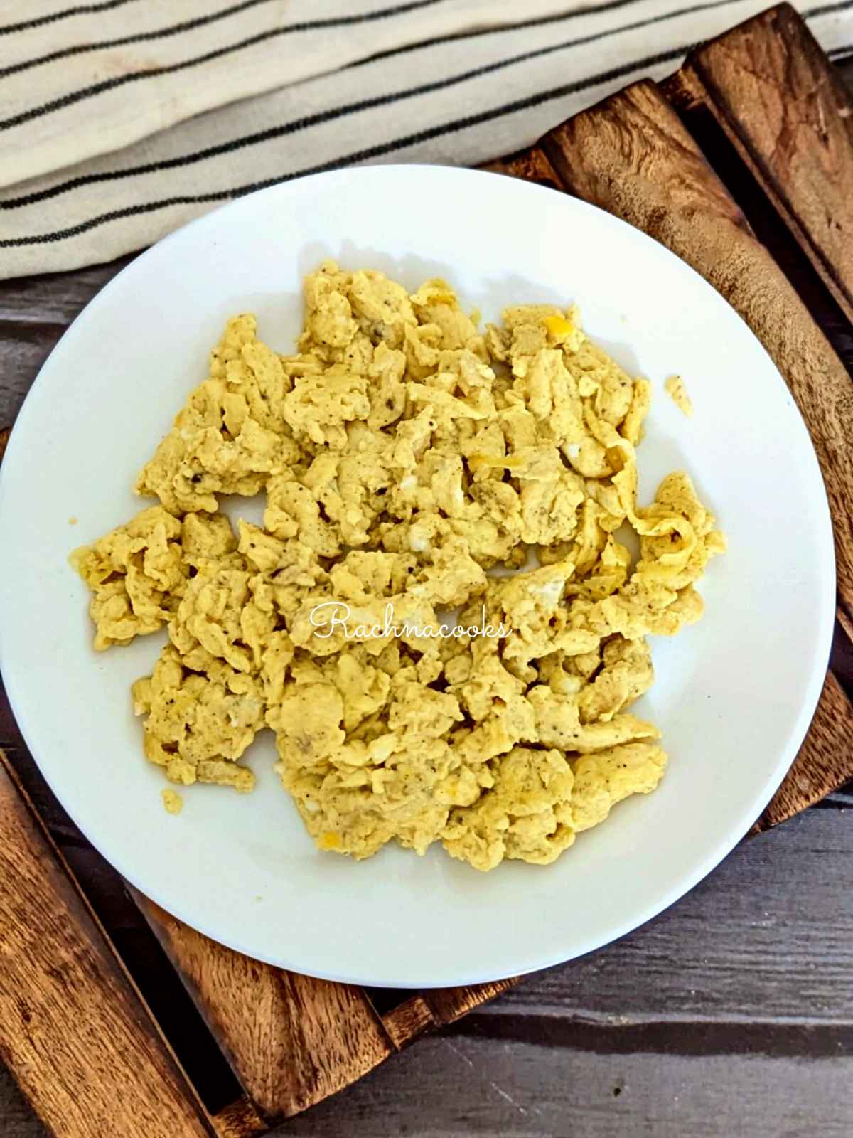 Scrambled eggs served on a white plate.