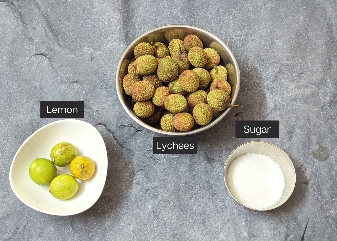 Whole lychees, lemon and sugar in bowls.