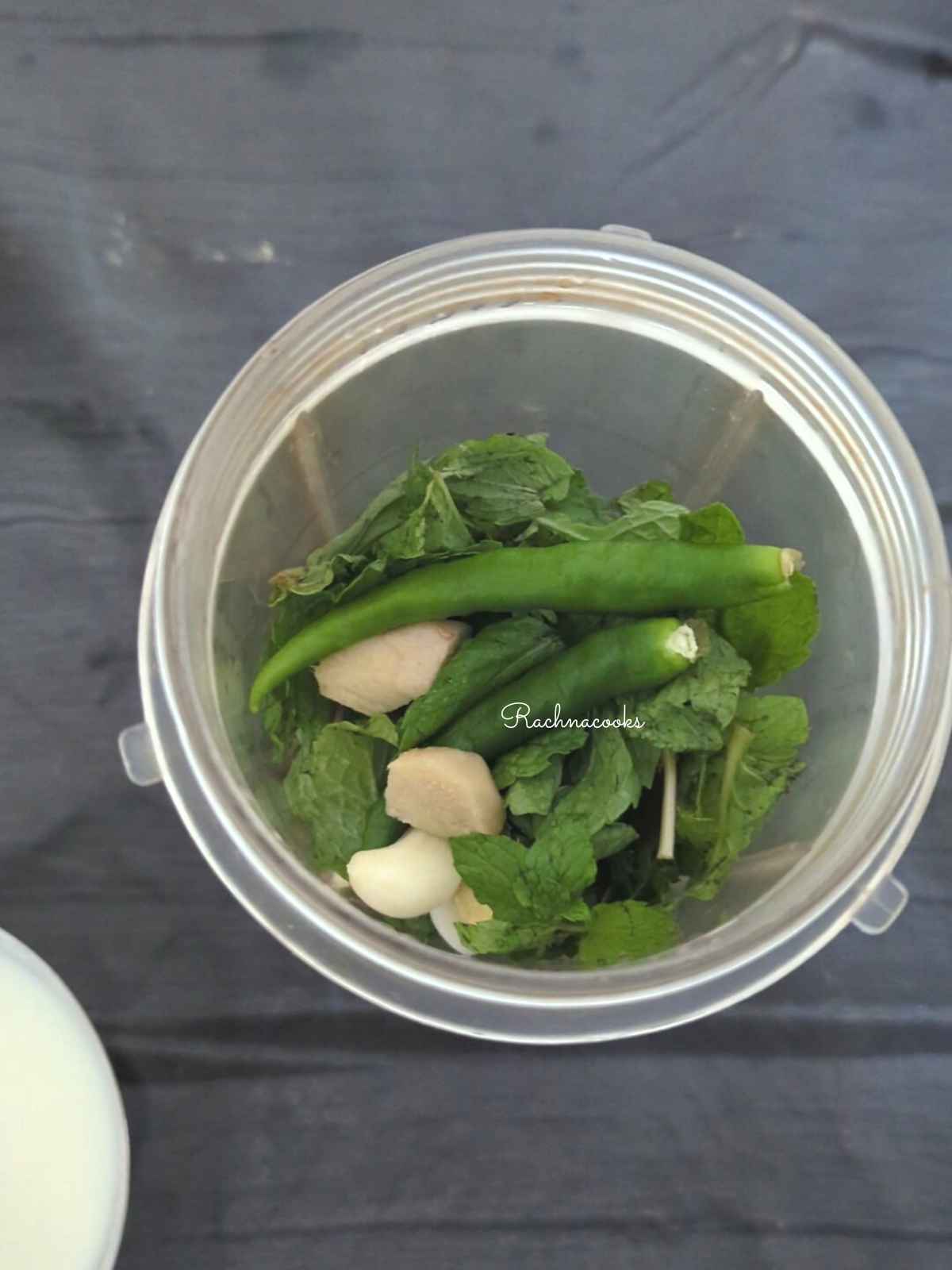 In a blender jar, mint, cilantro, ginger, garlic and green chillies are taken to blend.