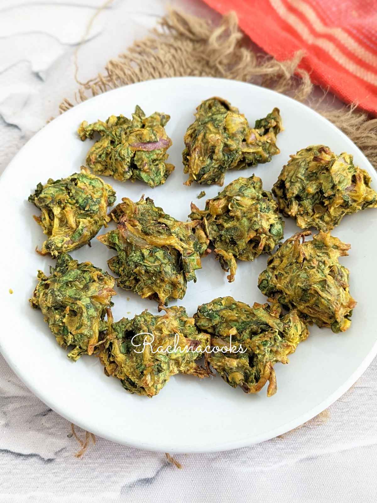 Close up of spinach pakoras on a white plate.