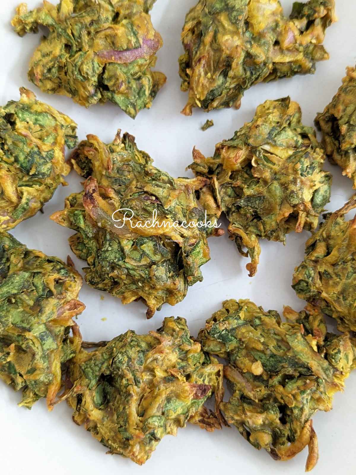 Close up of spinach pakoras on a white plate.
