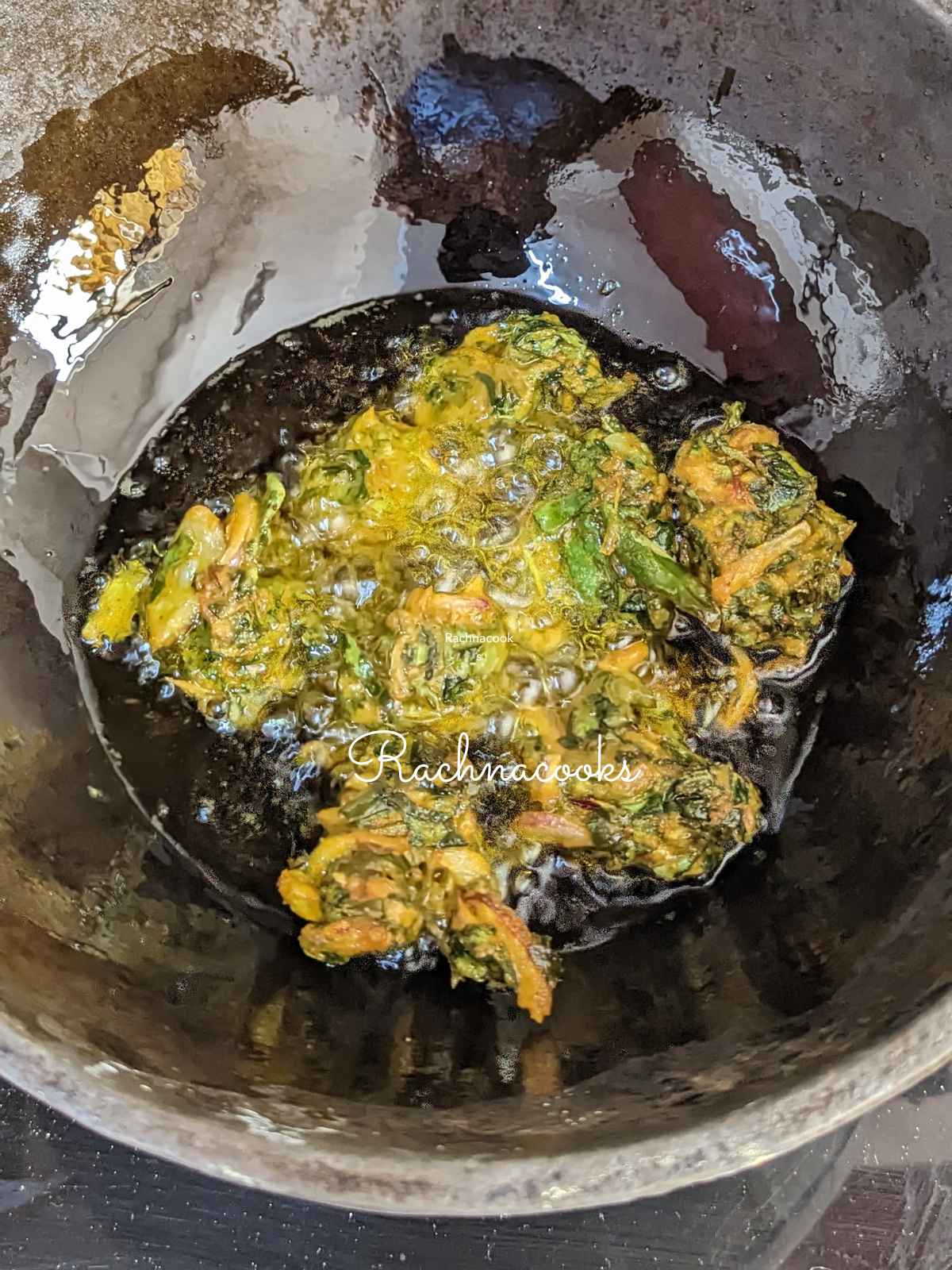 spinach pakore being fried in a kadhai