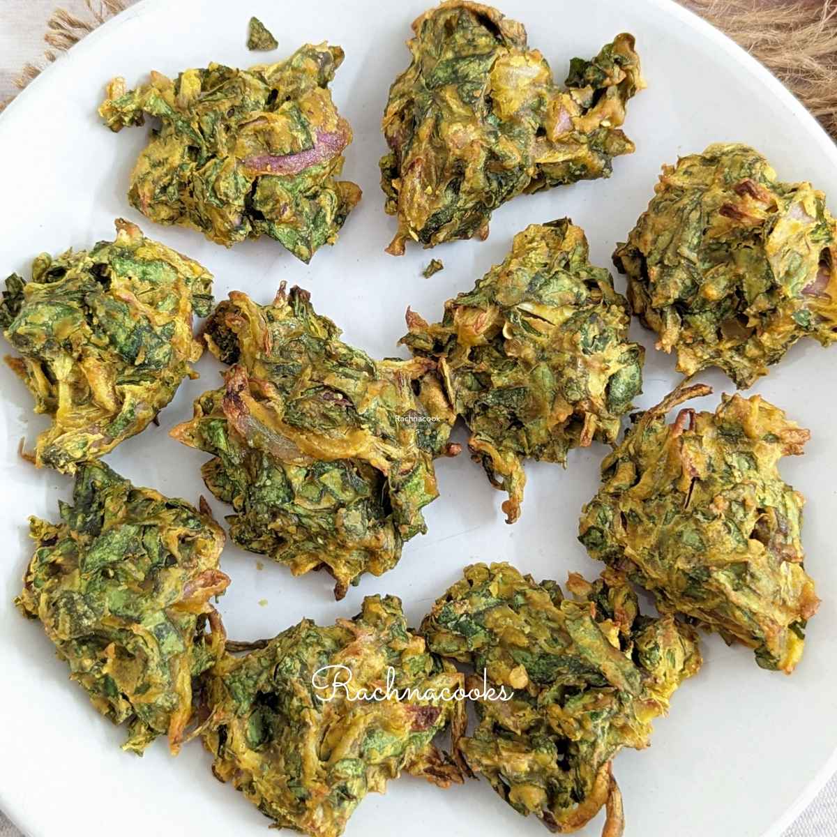 A plate of spinach pakodas on a white plate.