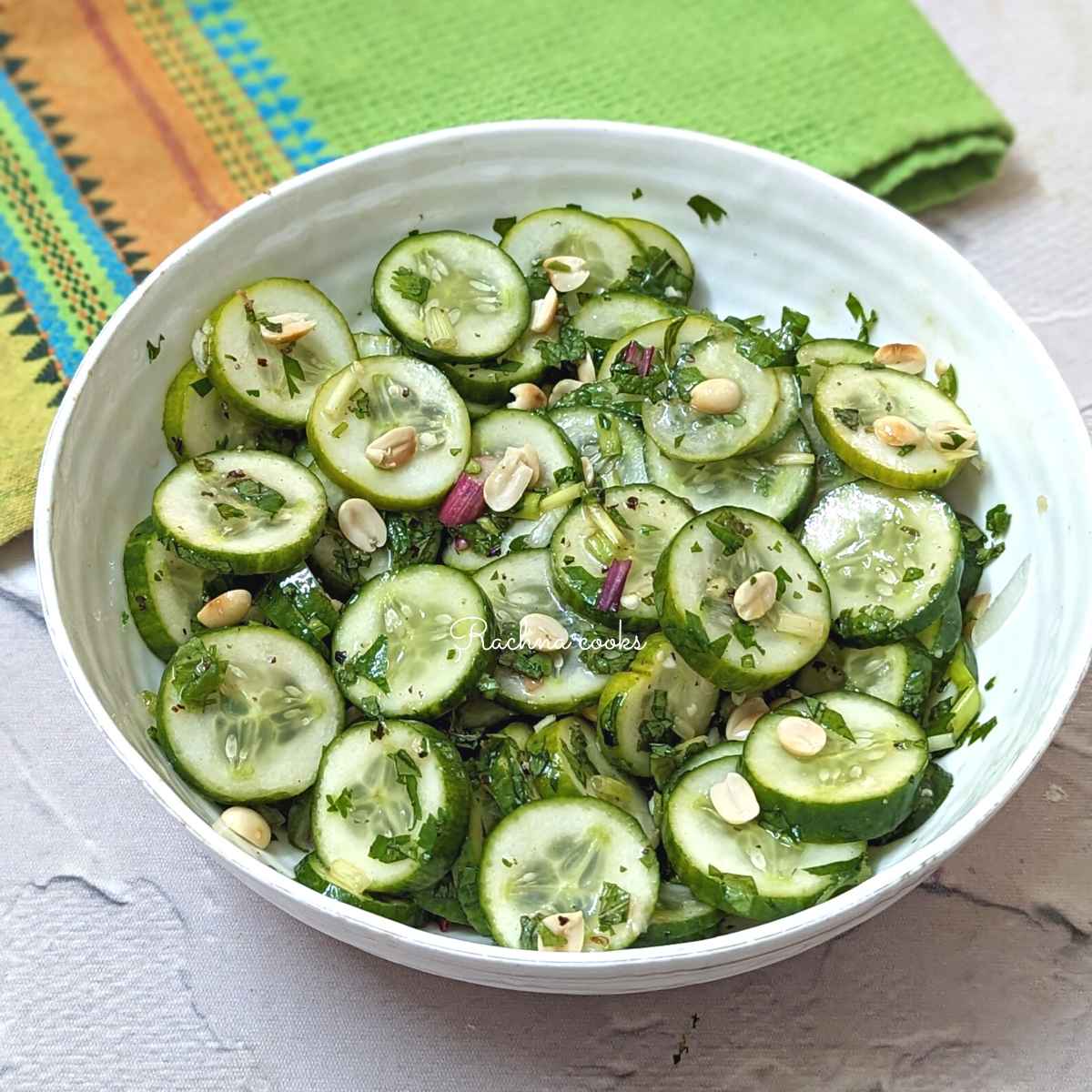 Vietnamese cucumber salad served in a white bowl with a garnish of peanuts.