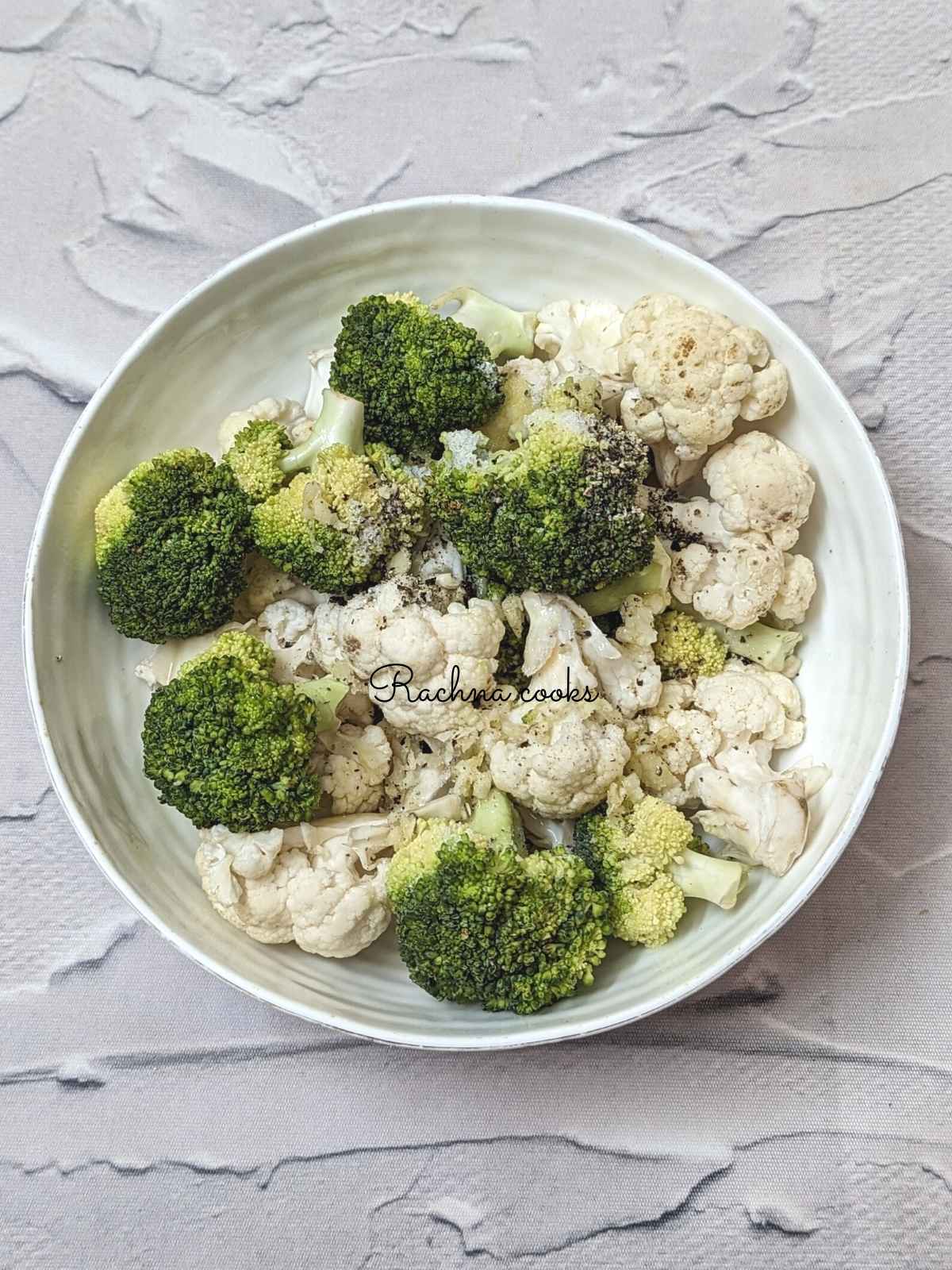 Cauliflower and broccoli florets in a bowl.