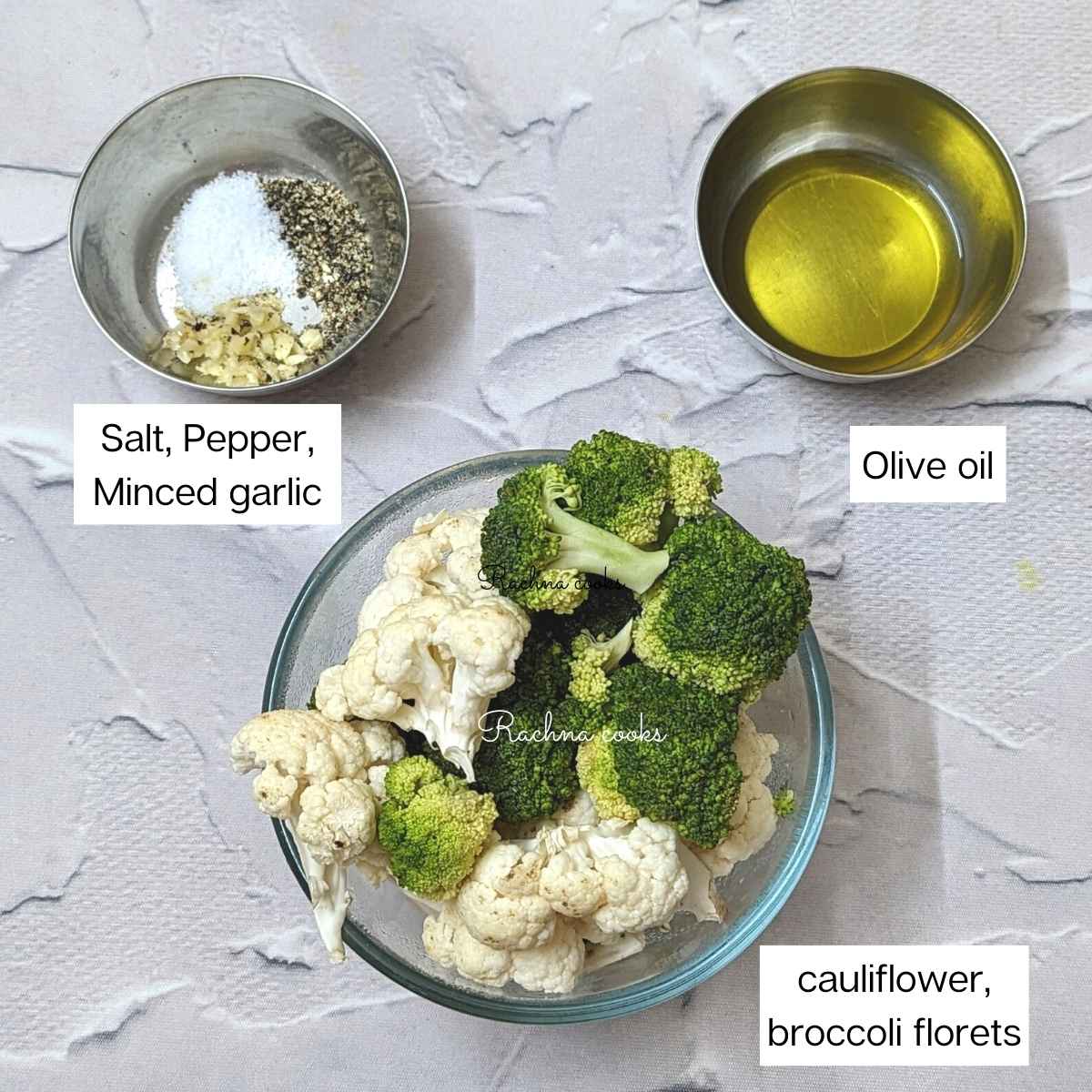 cauliflower, broccoli florets, olive oil, salt, pepper and minced garlic in bowls.